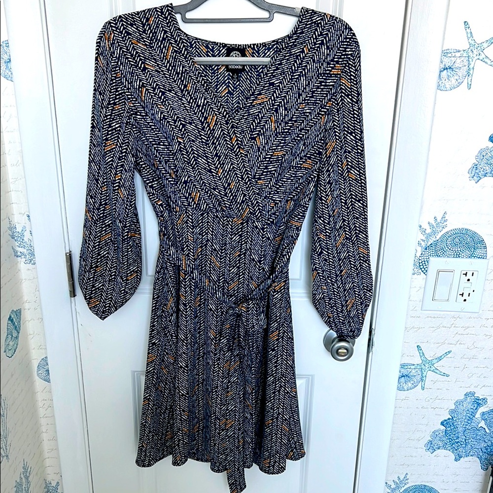 Elegant wrap dress in navy, white, and tan.